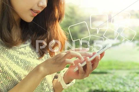 Beautiful woman playing and touching on smart phone screen in outdoor of home Stock Photos