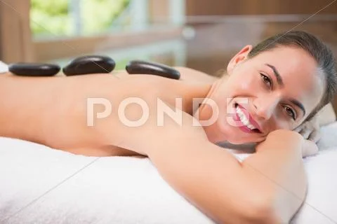Beautiful woman receiving stone massage at health farm Stock Photos