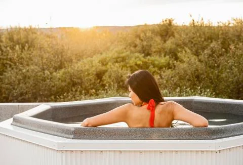 Beautiful woman relaxing in hot tub at holiday villa in Iceland Stock Photos