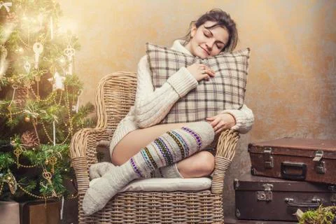 Beautiful woman relaxing sitting in a chair in the Christmas interior Stock Photos
