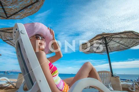 The beautiful woman rest on the sea beach Stock Photos