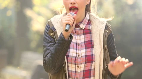 Beautiful woman singing with the microphone Stock Footage 59556568