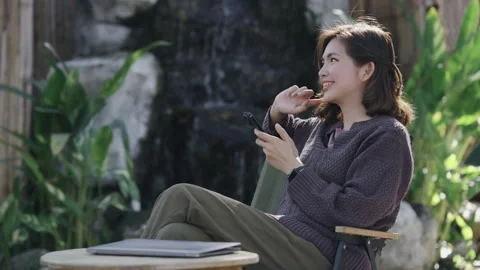 Beautiful woman sitting at a cafe using mobile phone and smiling. Female reading Stock Footage 261963377