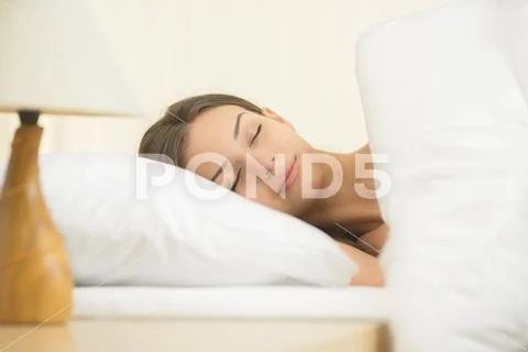 The beautiful woman sleeping on the bed with white linens Stock Photos