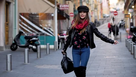 Beautiful woman smiling and looking into camera while walking on city street Stock Footage