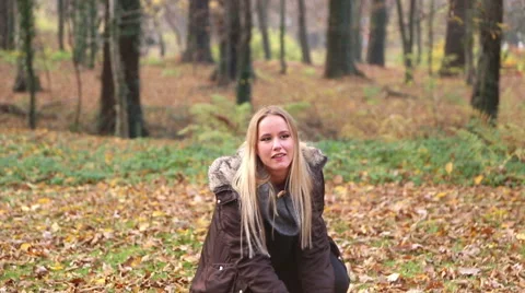 Beautiful woman smiling and throwing leaves in the park Stock Footage 59553853