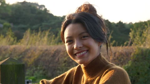 Beautiful woman smiling at camera while outdoors at sunset in autumn Video stock 139911499