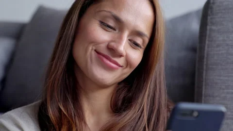 Beautiful woman smiling while checking her phone and reacting positively. Stock Footage 130599407