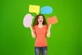 The beautiful woman stand with a dialog signs on the green background Photo