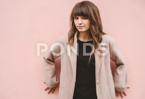 The beautiful woman stand on the pink wall background Stock Photos