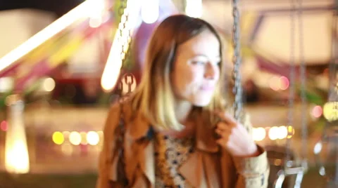 Beautiful woman on swing in amusement park Stock Footage 59556294