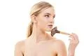 The beautiful woman using a cosmetic brush on the white background Photo