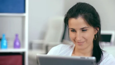 Beautiful woman using a digital tablet, while sitting on the couch at home Stock Footage 74370532