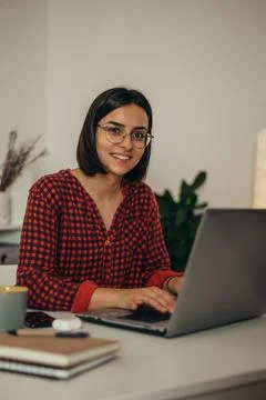 Beautiful woman using a laptop while working from home Stock Photos
