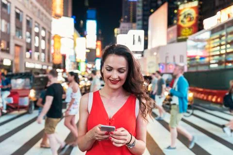 Beautiful woman using phone in Times Square. Stock Photos