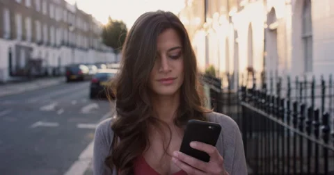 Beautiful woman using smart phone technology app walking through city Stock Footage 59149385