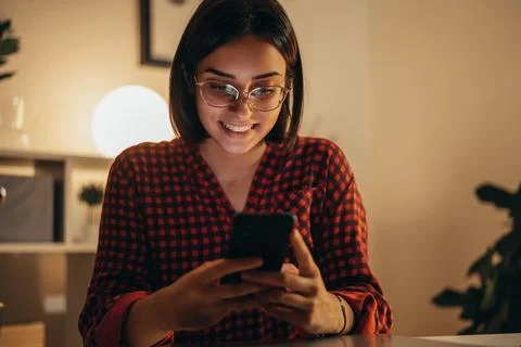 Beautiful woman using smartphone while working from home Stock Photos
