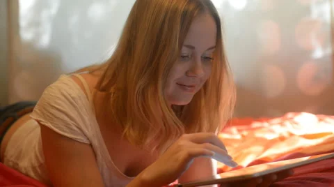 Beautiful woman using tablet lying on her bed Stock Footage 42006505