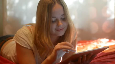 Beautiful woman using tablet lying on her bed Video stock 42006515