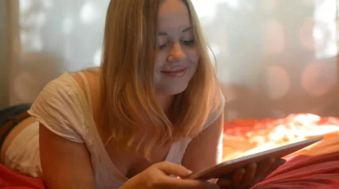 Beautiful woman using tablet lying on her bed Stock Footage 42006555