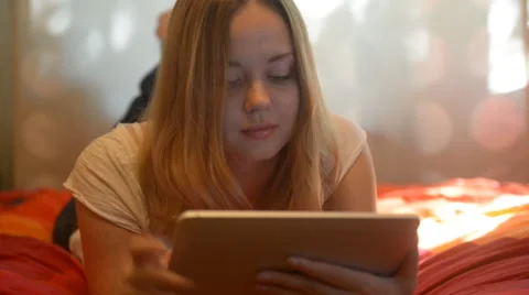Beautiful woman using tablet lying on her bed Stock Footage 42006753
