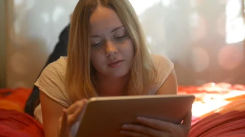 Beautiful woman using tablet lying on her bed Stock Footage 42006790