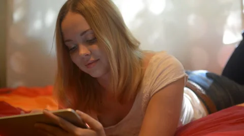 Beautiful woman using tablet lying on her bed Stock Footage 42007099