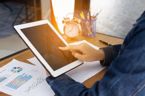 Beautiful woman using tablet while sitting at office desk. Stock Photos
