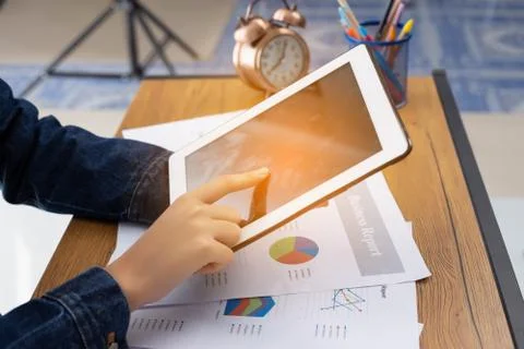 Beautiful woman using tablet while sitting at office desk. Stock Photos