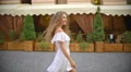 The beautiful woman walk along the restaurant terrace. Slow motion. Wide angle 4k or 4k+ Resolution