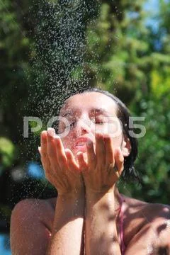 Beautiful woman washing and cleaning face under shower Stock Photos