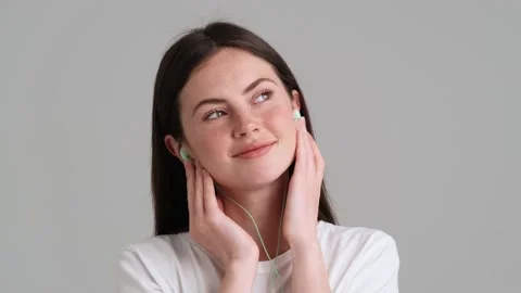 A beautiful woman wearing basic T-shirt is listening the music Video stock 154946023