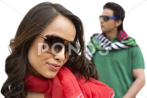Beautiful woman wearing sunglasses with her boyfriend in background Stock Photos