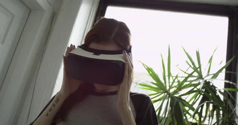 Beautiful woman wearing VR headset at home Stock Footage