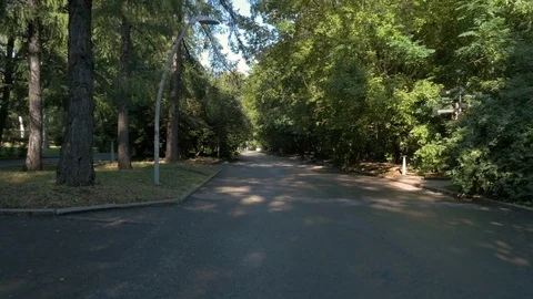 A beautiful woman in a white suit walks quickly and runs in the city park. Stock Footage