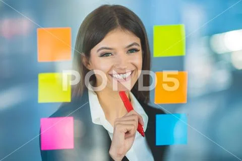 The beautiful woman writing a note on the sticker Stock Photos