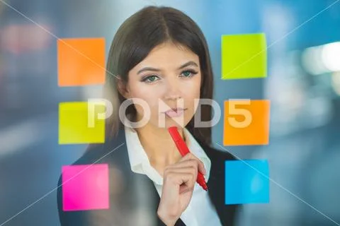 The beautiful woman writing a note on the sticker Stock Photos