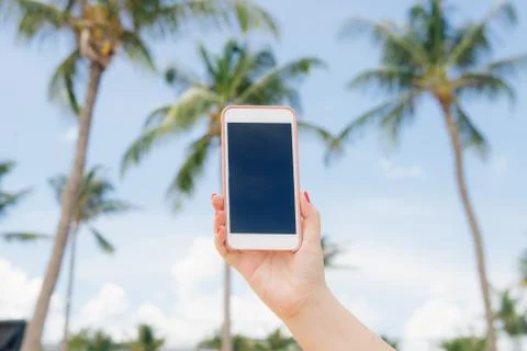 Beautiful woman's hand using smart phone at beach. Foto stock