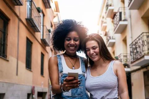 Beautiful women using a mobile in the Street. Stock Photos