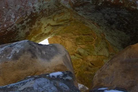 Beautiful yellow cave with rays of light in an ancient mountain. Background. Stock Photos
