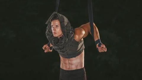 Beautiful young acrobat makes pull-ups on ropes Foto stock