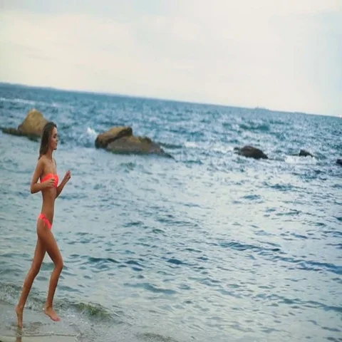 Beautiful young active woman training sport on the morning in a desert beach Stock Footage 69497466