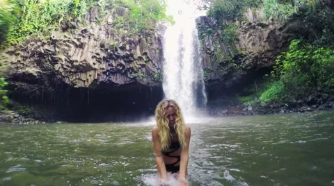 Beautiful Young Bikini Model Splashing Water at Camera in Lush Jungle Pond in Vidéo 55356960