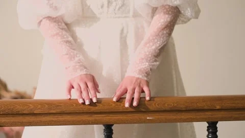 Beautiful young bride holds her hand on the railing while walking down the Stock Footage 328299599