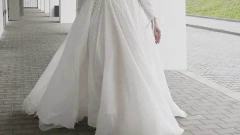 A beautiful young bride is walking down the street with her white dress 库存影片 306145348