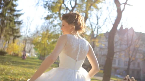 Beautiful young bride in white wedding dress spinning around. Happy bride Stock Footage 57457688