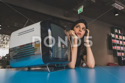 Beautiful young brunette posing beside a vintage tv Stock Photos