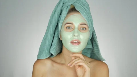 Beautiful young caucasian woman applying face mask on her face  Stock Footage