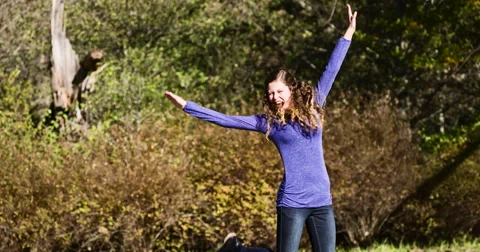 Beautiful young cheerleader type leaping into the air, cheering Stock Footage 54896941