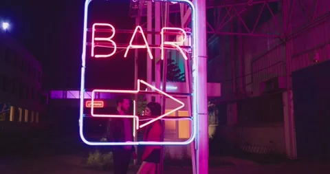 Beautiful young couple dancing and doing movement near bar neon sign lights Vídeos de archivo 201616114